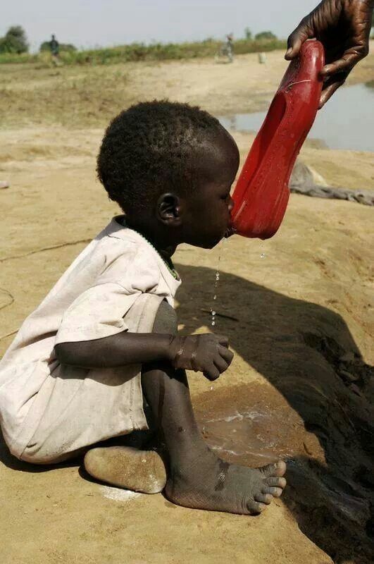 Child filling a bucket from a slow-running tap representing limited water access